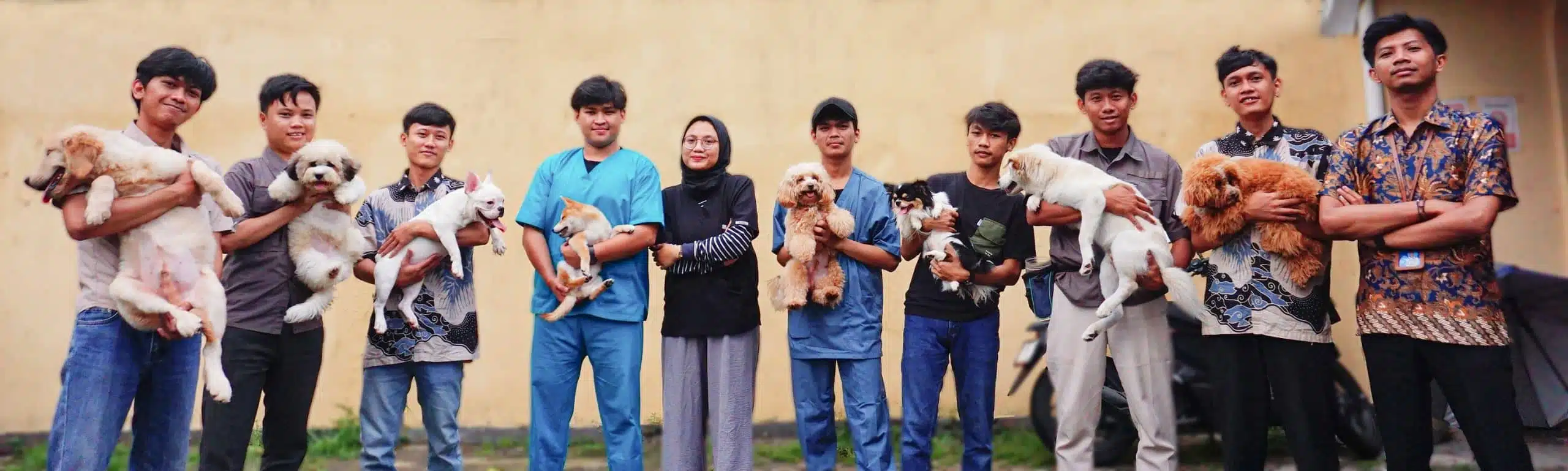 Foto bersama tim FaunaFella Dog sambil menggendong anjing berbagai ras